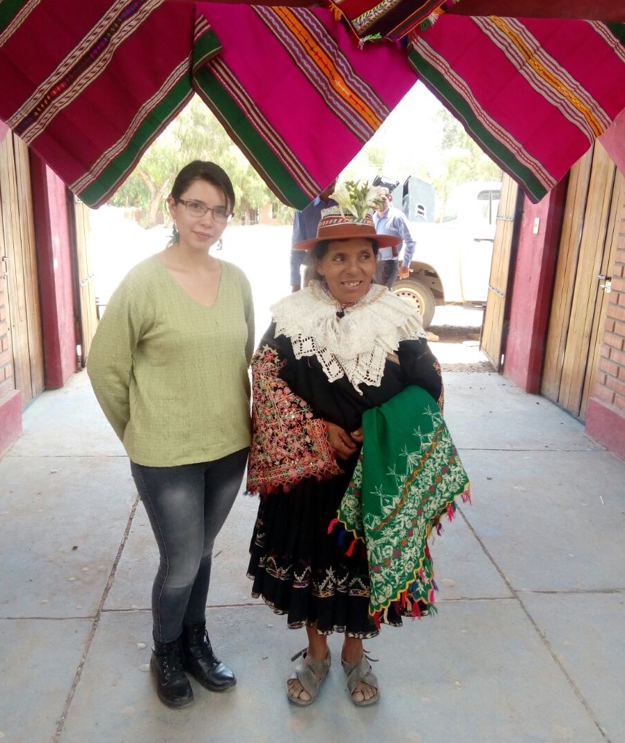 Junto a mujer con vestimenta tradicional y llijllas tejidas al fondo. Vitichi, 2017
