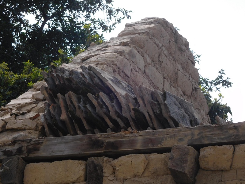 Muro
hastial o piñón de adobe, con tejas planas orladas o lobuladas de barro rojo
recocido