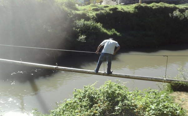 Antes (2011). Imagen tomada desde área verde La Pradera, persona transita por un tubo de agua, adaptado de manera informal