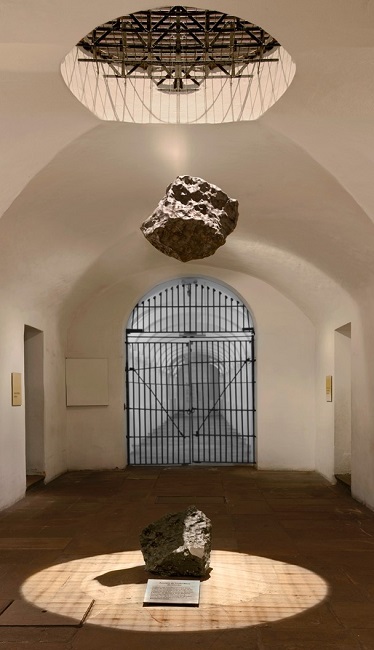 Fotografía de 
la instalación Eclipse 
en el Museo Nacional. 
Se puede ver la réplica 
del aerolito suspendida 
sobre el aerolito original.  Proyecto Pequeño Museo 
del Aerolito de Santa Rosa 
de Viterbo de María Elvira 
Escallón (2015)