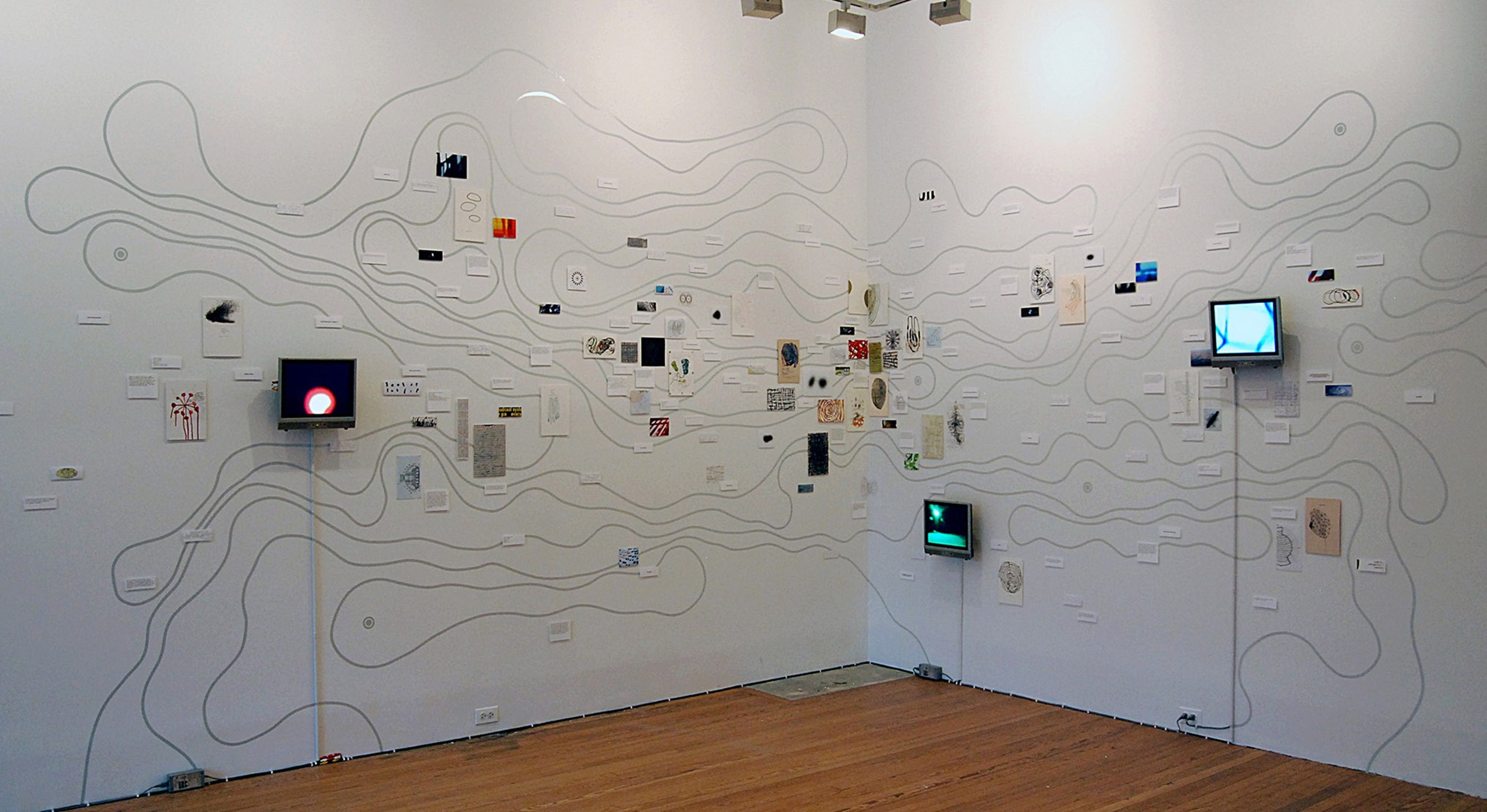 
Nayda Collazo- Llorens, Unfolding the Triangle (NYC), 2011. Wall installation with
videos, reflective tape, and mixed
media on paper. 

Installation view at 80WSE Galleries,
New York, NY. Courtesy of the artist.